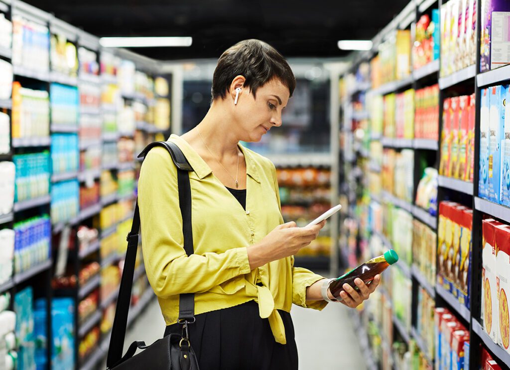 donna che scannerizza codice a barre di un prodotto al supermercato
