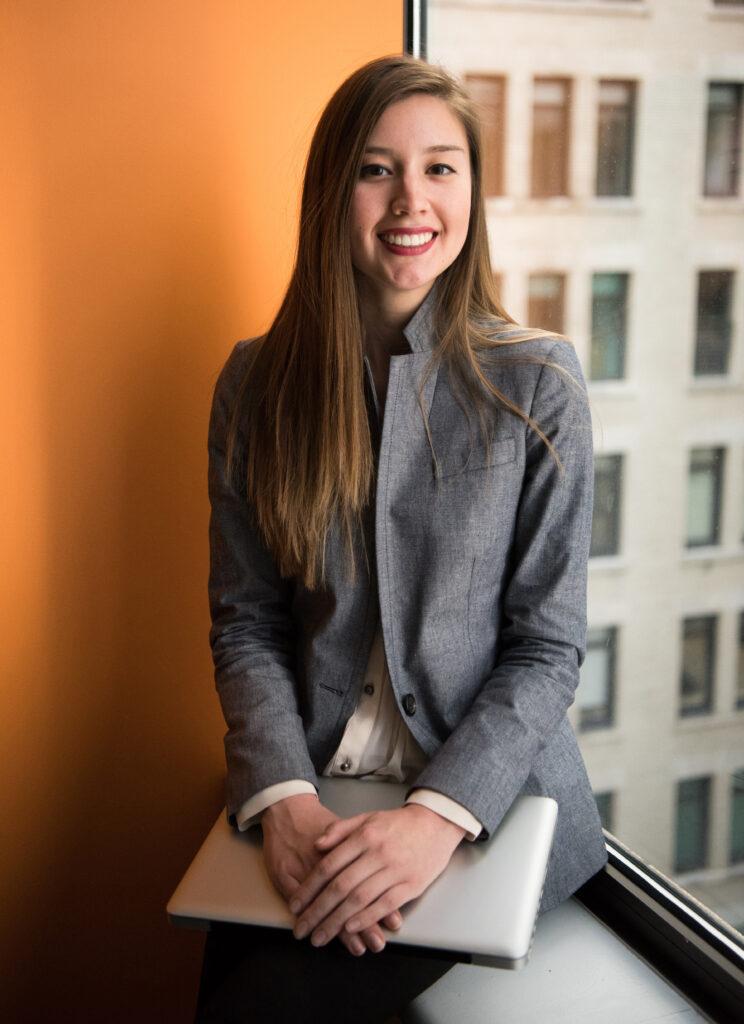 Ragazza elegante in ufficio con il computer in mano